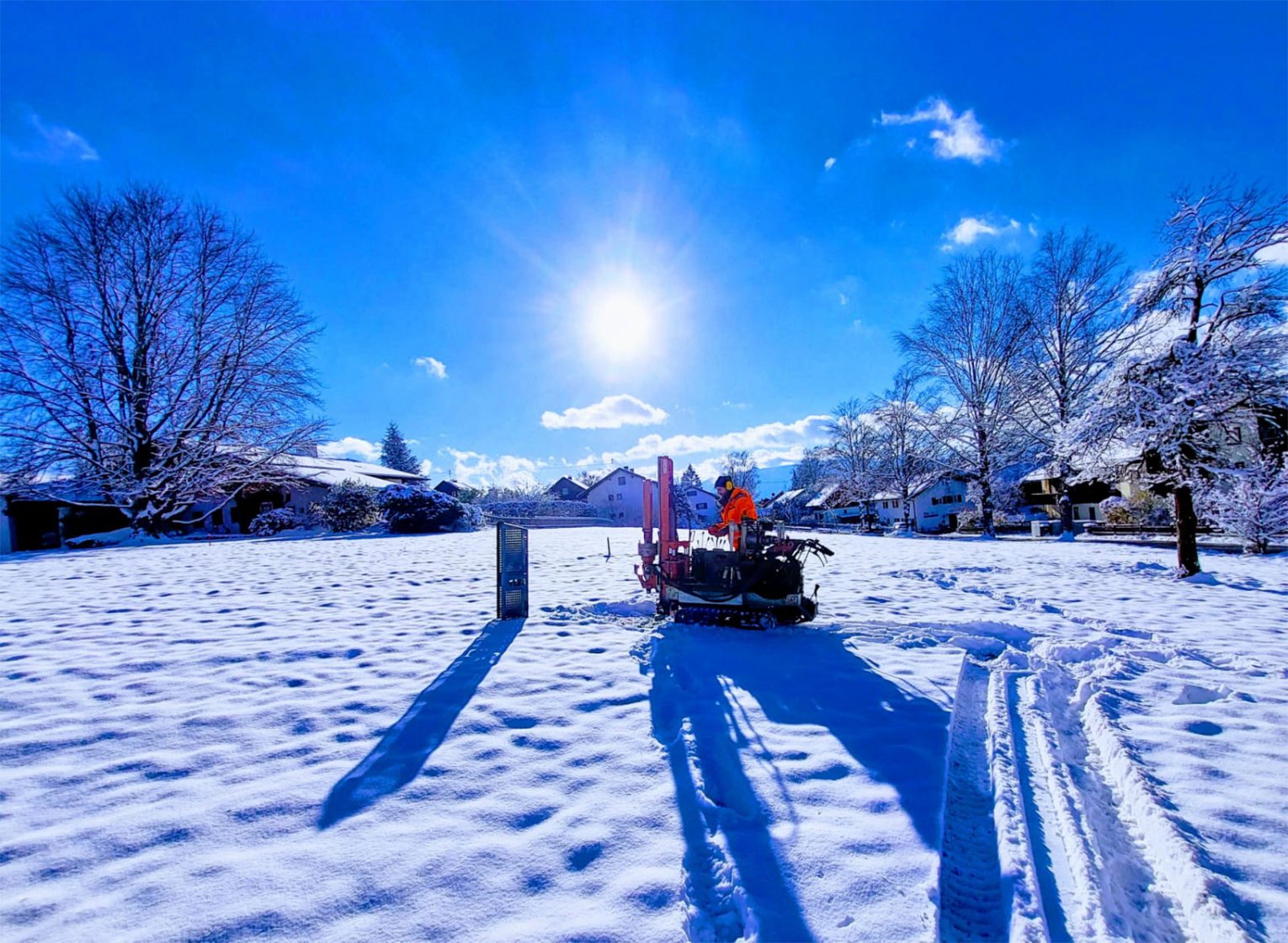 Kleinbohrung in schneebedeckter Landschaft, im Hintergrund blauer Himmel.